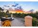 Outdoor deck with wicker furniture and views of surrounding trees during sunset at 724 Evening Star Dr, Castle Rock, CO 80108