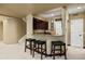 This wet bar features bar stool seating, built in shelving, and is located next to the stairs at 724 Evening Star Dr, Castle Rock, CO 80108