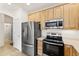 Stainless steel appliances and light wood cabinets in a bright kitchen at 22263 E Euclid Dr, Aurora, CO 80016