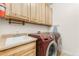 Laundry room with washer, dryer, and wooden cabinets at 22263 E Euclid Dr, Aurora, CO 80016