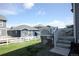 Well-maintained backyard with a deck, a green lawn, white fencing, and views of neighboring homes at 4955 Trails Edge Ln, Castle Rock, CO 80104