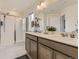 Bright bathroom featuring a double vanity, large mirror, and glass enclosed shower with white tile at 4955 Trails Edge Ln, Castle Rock, CO 80104