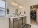 Well-lit bathroom featuring a double vanity, large mirror, and access to a walk-in closet at 4955 Trails Edge Ln, Castle Rock, CO 80104