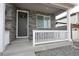 Close-up of front door with stone accents and a charming white porch railing at 4955 Trails Edge Ln, Castle Rock, CO 80104