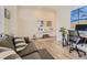 Bright living room featuring a gray sofa, a workstation, and hardwood floors, creating a comfortable space at 4955 Trails Edge Ln, Castle Rock, CO 80104