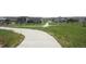 Scenic walking path with lush green grass, landscaping, and neighborhood homes in the background at 4955 Trails Edge Ln, Castle Rock, CO 80104
