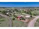 Aerial shot of property featuring an equestrian ring and outbuildings surrounded by lots of trees at 36921 Ruger Ct, Elizabeth, CO 80107