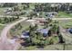 Wide aerial view of property featuring multiple outbuildings, an equestrian ring, and mature trees at 36921 Ruger Ct, Elizabeth, CO 80107