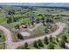 High angle view of property featuring circle driveway, horse property, and lots of trees at 36921 Ruger Ct, Elizabeth, CO 80107
