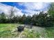 Backyard with mature trees, a bench, and a metal fire pit at 36921 Ruger Ct, Elizabeth, CO 80107