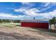 Exterior view of a red barn with white trim and nearby fenced paddock at 36921 Ruger Ct, Elizabeth, CO 80107