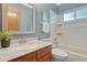 Cozy bathroom with vanity, mirror, and bathtub with shower, all with blue wall accents at 36921 Ruger Ct, Elizabeth, CO 80107
