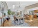 Open-concept dining room featuring a wood table set for four, hardwood floors, and a view into the living room at 36921 Ruger Ct, Elizabeth, CO 80107