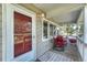 Inviting front porch with rocking chairs, flower pots, and a welcoming red door at 36921 Ruger Ct, Elizabeth, CO 80107