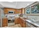 Well-lit kitchen with stainless steel appliances, wood cabinets, and a copper sink under a bright window at 36921 Ruger Ct, Elizabeth, CO 80107