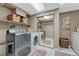 Bright laundry room featuring modern washer, dryer, storage and a mirror sliding-door closet at 36921 Ruger Ct, Elizabeth, CO 80107