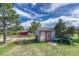 Well-maintained shed with lawn mower and red barn in the background at 36921 Ruger Ct, Elizabeth, CO 80107