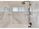 Bright shower featuring a full marble enclosure and updated fixtures at 36921 Ruger Ct, Elizabeth, CO 80107