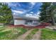Back of house featuring spacious sunroom with patio and landscaped yard at 36921 Ruger Ct, Elizabeth, CO 80107