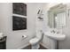 Cozy half bathroom featuring modern fixtures, stylish decor, and a clean design with a pedestal sink at 21271 E Smoky Hill Rd, Centennial, CO 80015
