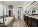 Stylish bathroom featuring dual sinks, soaking tub, decorative accents, and modern fixtures create a clean and inviting space at 21271 E Smoky Hill Rd, Centennial, CO 80015