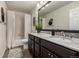 Bathroom features dark wooden cabinets, a bathtub with white curtain, and a modern mirror at 21271 E Smoky Hill Rd, Centennial, CO 80015