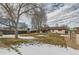 Large backyard with mature trees, shed, and partially snow-covered lawn at 6196 W 66Th Ave, Arvada, CO 80003