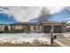 House exterior showcasing a snow-covered yard and attached garage at 6196 W 66Th Ave, Arvada, CO 80003