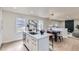 Open concept kitchen with island, white cabinets and stainless steel appliances at 6196 W 66Th Ave, Arvada, CO 80003