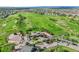Aerial view showcasing golf course community with clubhouse and lush green surroundings at 12000 Pine Top St, Parker, CO 80138