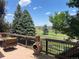 Relaxing back deck featuring a cozy lounge chair, fire pit, and scenic views of the lush golf course and distant horizon at 12000 Pine Top St, Parker, CO 80138