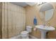 Cozy bathroom featuring pedestal sink, a round mirror and a shower with patterned curtain at 12000 Pine Top St, Parker, CO 80138