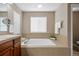 Relaxing soaking tub with tile surround and natural light at 12000 Pine Top St, Parker, CO 80138