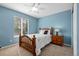 Cozy bedroom features a wood bed frame, bright window, blue walls and neutral carpet at 12000 Pine Top St, Parker, CO 80138