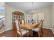Formal dining room featuring hardwood floors, elegant chandelier, and china cabinet display at 12000 Pine Top St, Parker, CO 80138