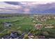 Vast aerial view showcasing sports fields, a lake, and residential areas beneath a cloudy sky at 10723 W 54Th Pl, Arvada, CO 80002