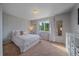 Bright bedroom with a plush bed, soft carpet, and natural light streaming through a window, creating a serene retreat at 10723 W 54Th Pl, Arvada, CO 80002