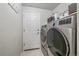 Well-equipped laundry room featuring a modern washer and dryer, complemented by storage shelves and a convenient door at 10723 W 54Th Pl, Arvada, CO 80002