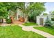 Expansive backyard featuring a large deck, mature trees, and lush greenery with brick paver walkway at 677 N Gilpin St, Denver, CO 80218