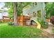 Lush backyard featuring a wooden deck, play structure, and mature trees creating a serene outdoor space at 677 N Gilpin St, Denver, CO 80218