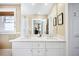 Bright bathroom boasts double sinks, marble countertops, and a large mirror reflecting the bedroom at 677 N Gilpin St, Denver, CO 80218