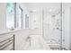 Bright bathroom featuring a soaking tub, glass-enclosed shower, and natural light from large windows at 677 N Gilpin St, Denver, CO 80218