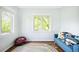 Bright bedroom featuring hardwood floors, two windows, and a cozy blue couch with playful pillows at 677 N Gilpin St, Denver, CO 80218