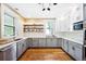 Bright kitchen with white subway tile, gray cabinets, stainless appliances, and open wood shelves at 677 N Gilpin St, Denver, CO 80218