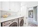 Functional laundry room with marble countertops, stainless steel machines, and ample storage at 677 N Gilpin St, Denver, CO 80218