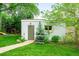 Exterior of outbuilding featuring a green door, trimmed evergreen, and lush green lawn at 677 N Gilpin St, Denver, CO 80218