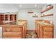 Basement bar area with warm wood cabinets, granite countertops, shelving, and ample space for entertaining at 9868 Overlook Rd, Sedalia, CO 80135