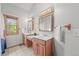Bathroom featuring double sinks and vanities, a window, and neutral color scheme at 9868 Overlook Rd, Sedalia, CO 80135