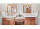 Bathroom featuring double sinks, wooden cabinetry, vanity and neutral toned tile floors at 9868 Overlook Rd, Sedalia, CO 80135