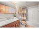 Bathroom with wood accents featuring a single sink vanity, mirror, toilet, and shower/tub combo at 9868 Overlook Rd, Sedalia, CO 80135